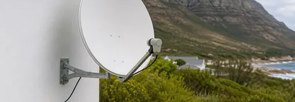 DSTV Installations Kommetjie technician taking a call beside the van at Long Beach