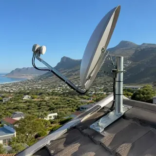 Satellite dish aligned against the Slangkop lighthouse skyline